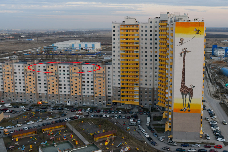 Фотография сделана в марте 2014 года, официально дом не введен в эксплуатацию, тем не менее, видно, что в окнах горит свет, а на парковке - машины жильцов. Этажей в доме 11 - заметно, что размер окон последнего этажа несколько отличается от остальных